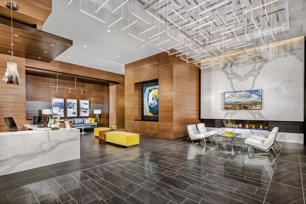 the lobby of a hotel with a reception desk and a fireplace
