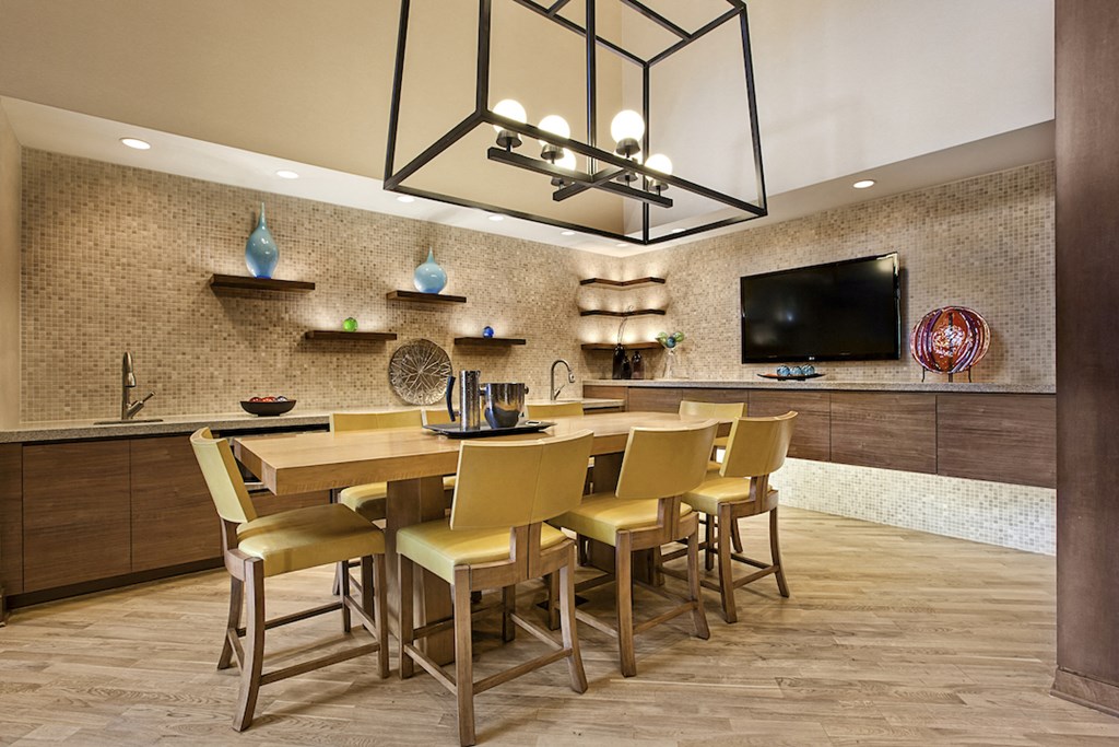 a dining room with a long table and chairs under a chandelier