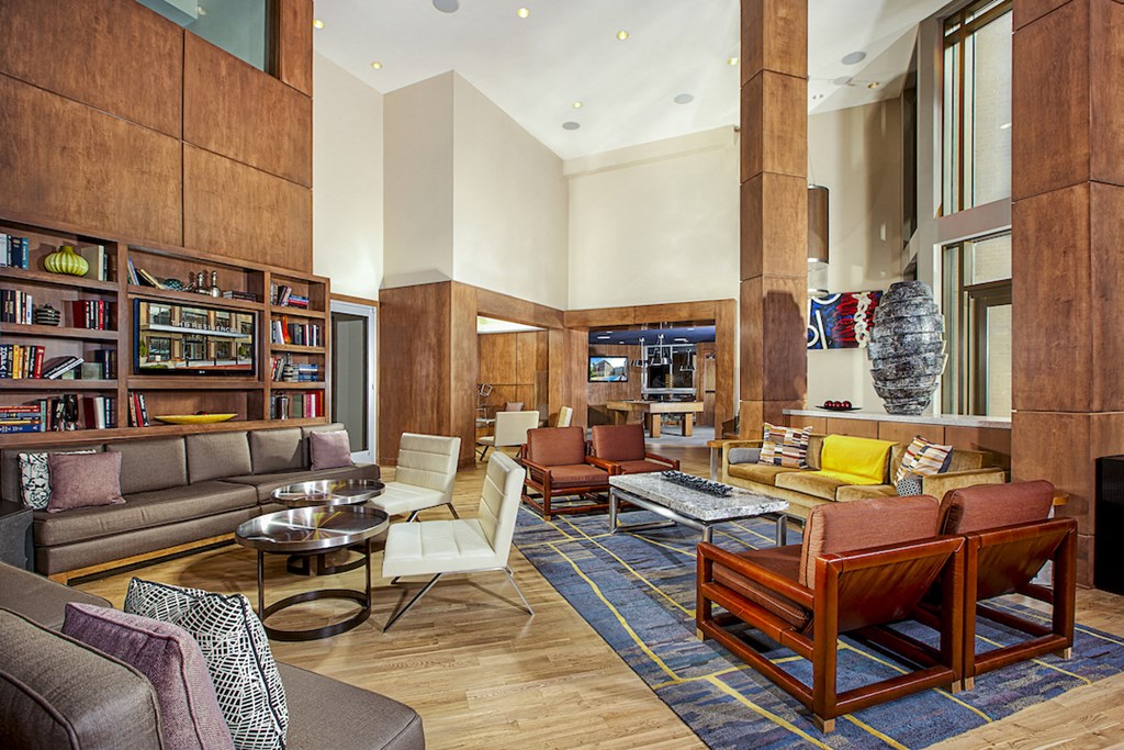a living room with couches and chairs and a library
