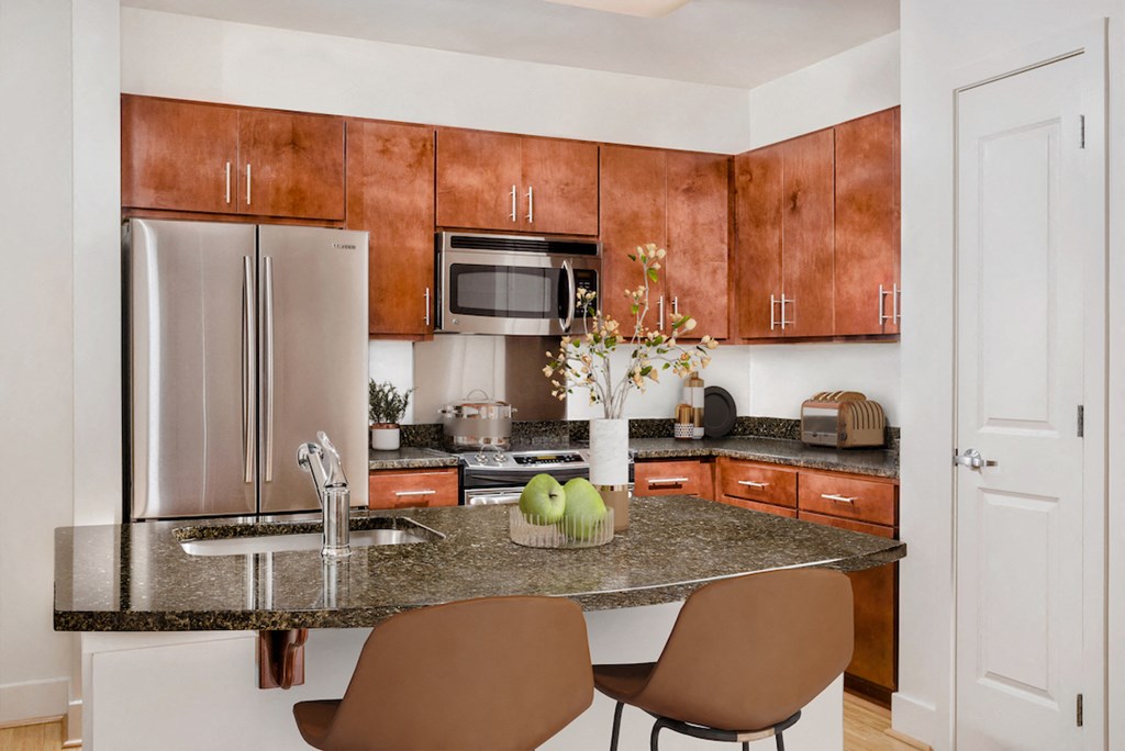 a kitchen with granite counter tops and a stainless steel refrigerator