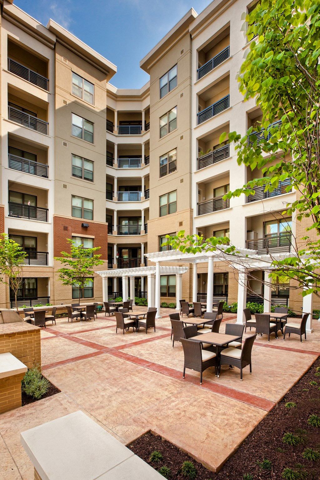an outdoor courtyard with tables and chairs at an apartment building