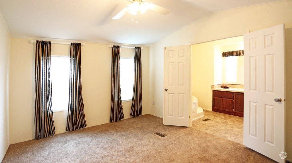 an empty room with a bathroom and a white door