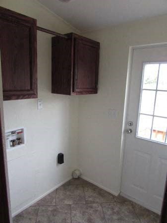a kitchen with brown cabinets and a white door