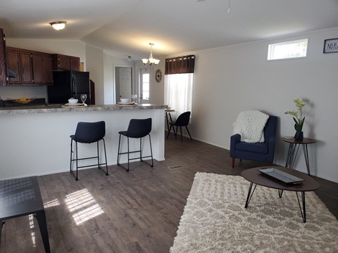 A kitchen with a bar and chairs.