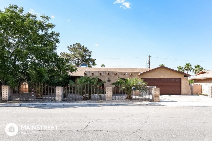 a house with a gate and a driveway in front of it