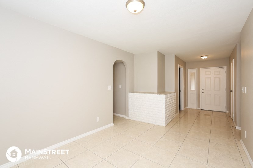 the living room and entryway of an empty house