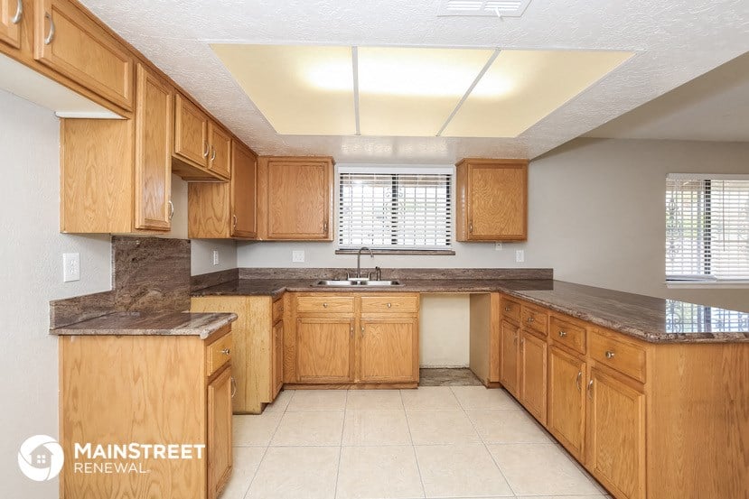 a large kitchen with wooden cabinets and a sink