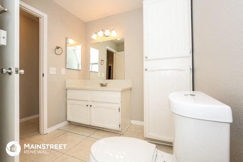 a bathroom with a toilet and a sink and a mirror