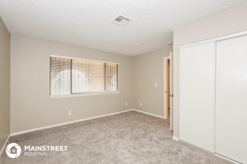 a bedroom with a door to a closet and a window