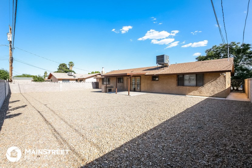a house with a gravel parking lot and a driveway