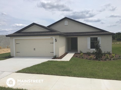 a white house with a lawn and a driveway