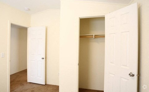 A white door is open to a room with a shelf.