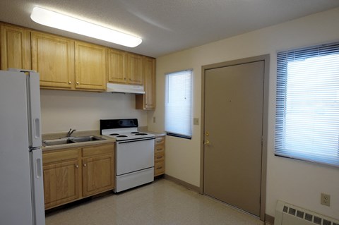 A kitchen with wooden cabinets and white appliances.