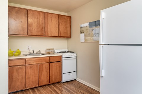 A kitchen with wooden cabinets and a white fridge.
