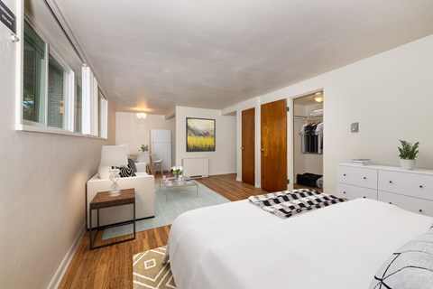 A bedroom with a white bed and a white dresser.