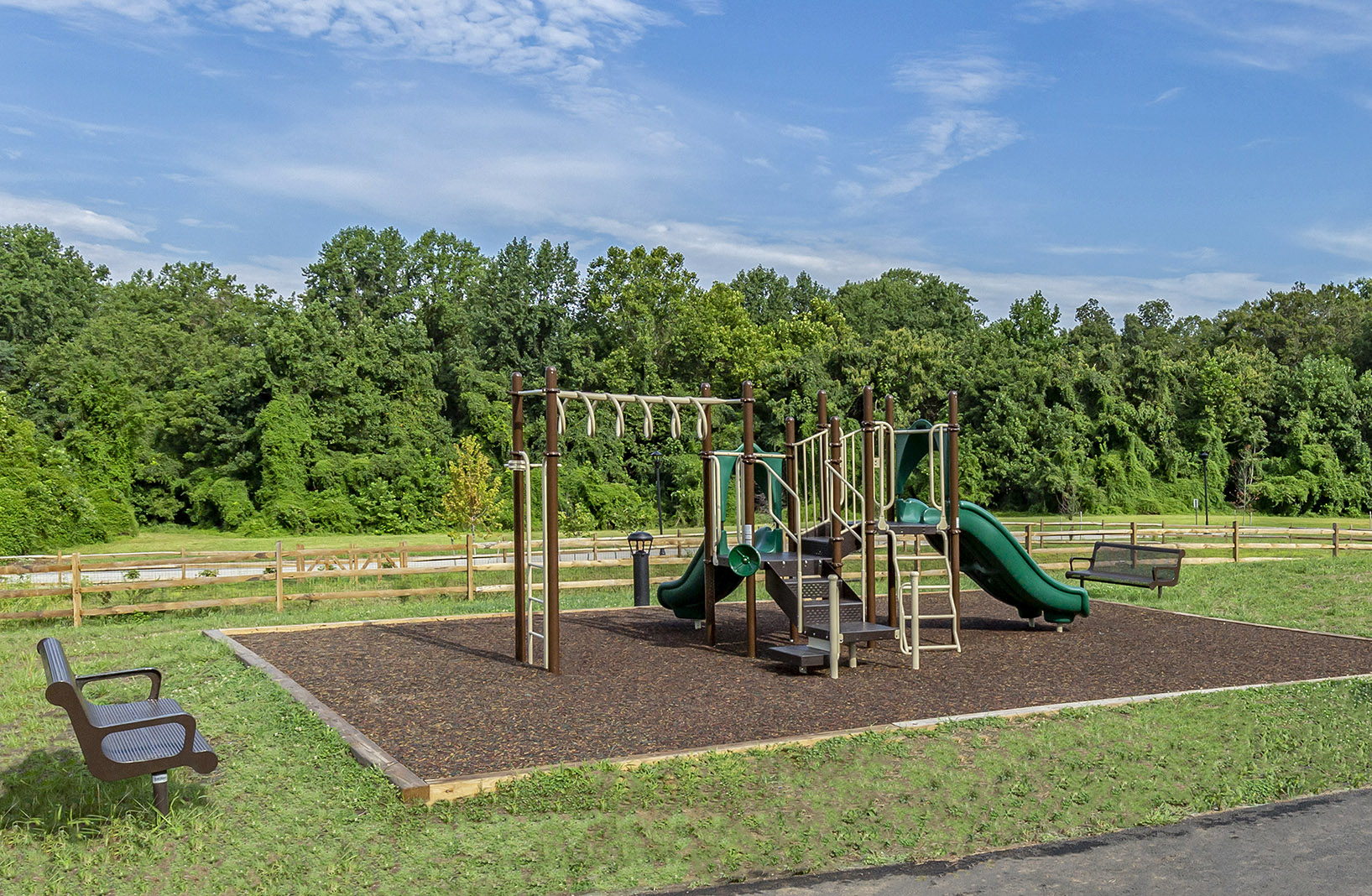 a playground with slides and a bench in a park