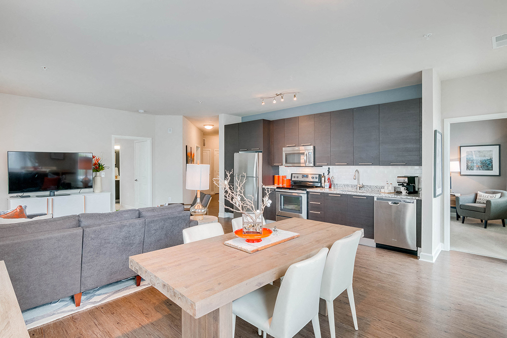 a living room with a dining room table and a kitchen
