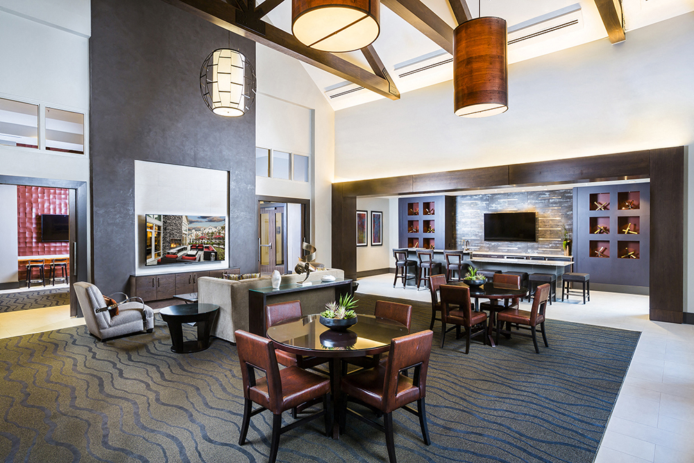 a living room and dining area in a hotel with a table and chairs