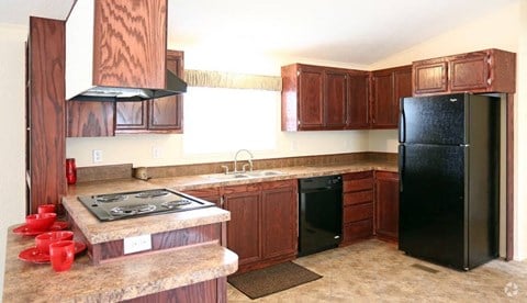 a kitchen with a stove and a black refrigerator