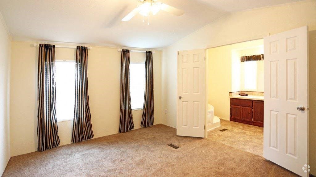 an empty room with a bathroom and a white door