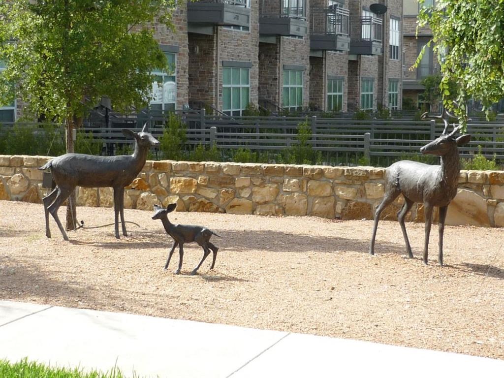 a group of deer and a baby deer in a zoo enclosure