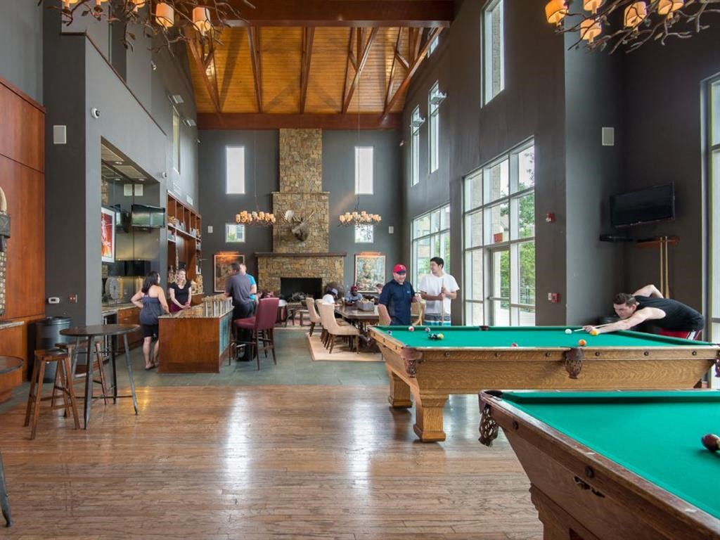 a group of people sitting around pool tables in a lobby