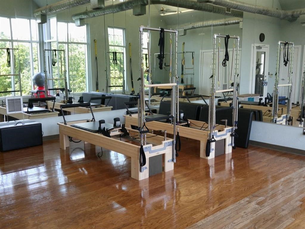 a gym with weights and machines on a wooden floor