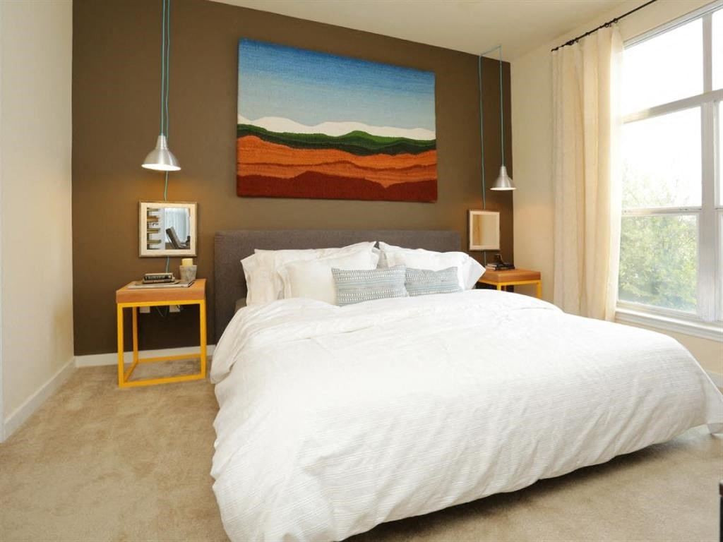a bedroom with a white bed and a painting on the wall