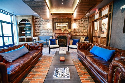 a living room with leather couches and a chess board