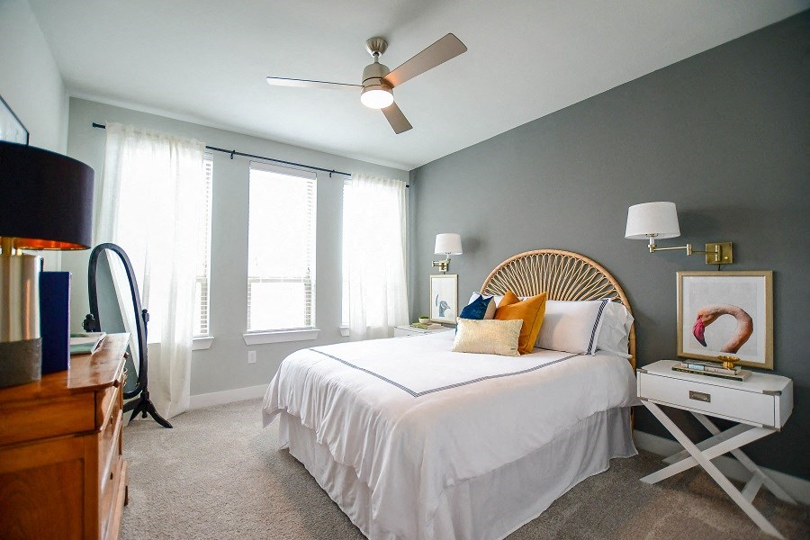 a bedroom with a white bed and a ceiling fan