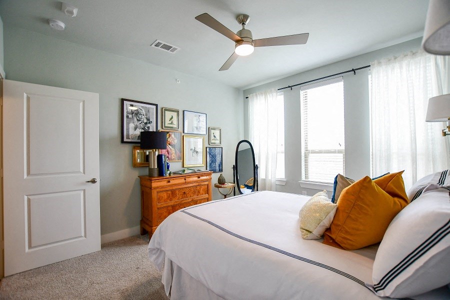 a bedroom with a bed and a ceiling fan