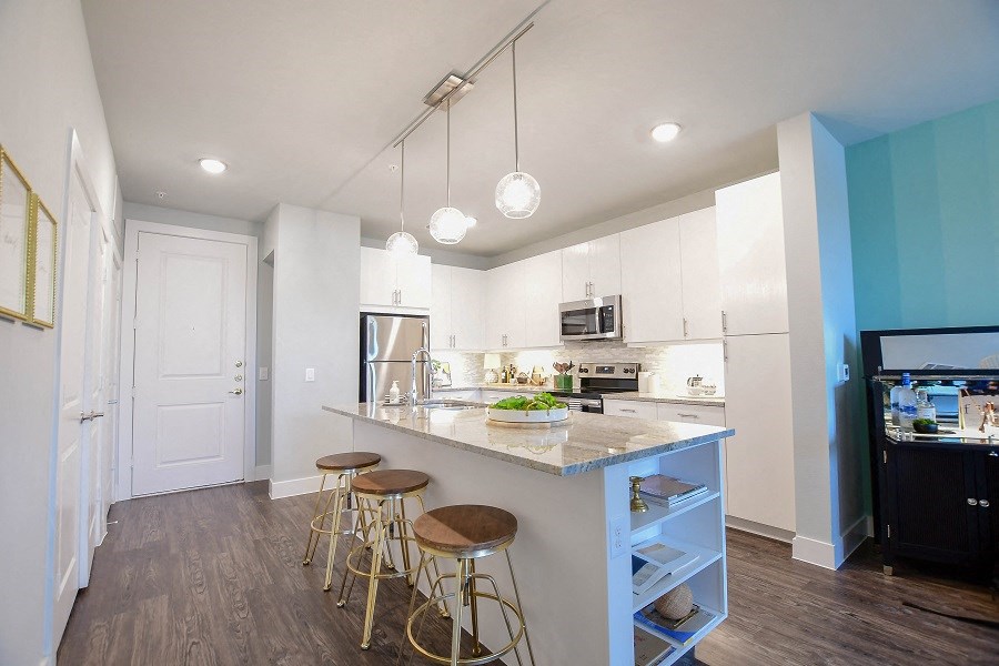 a kitchen with a large island with bar stools