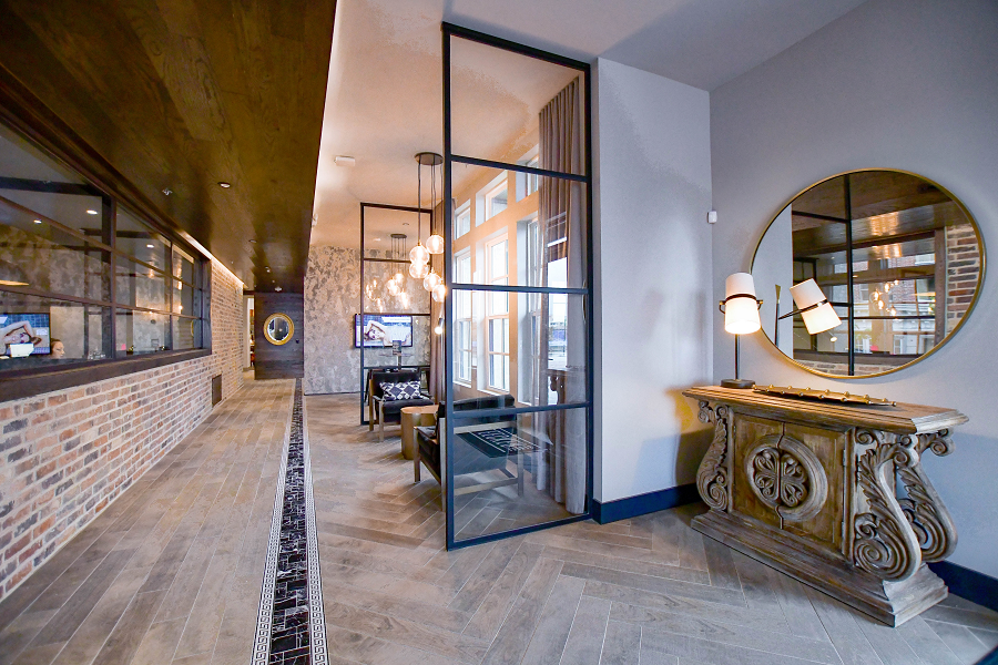 a hallway with glass doors and a table with a mirror