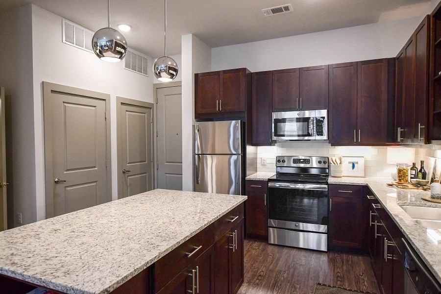 a kitchen with stainless steel appliances and a marble counter top