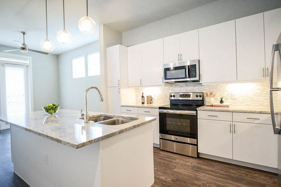 a kitchen with white cabinets and stainless steel appliances
