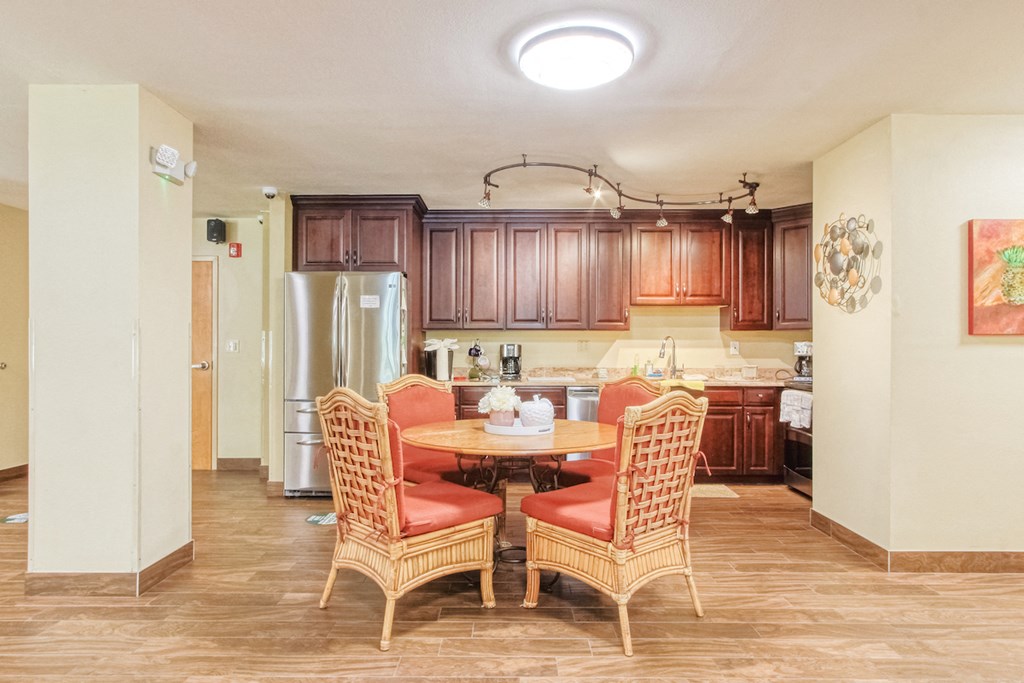 VSC-CommunityKitchen community kitchen with table, chairs, fridge, cabinetry, and track lighting