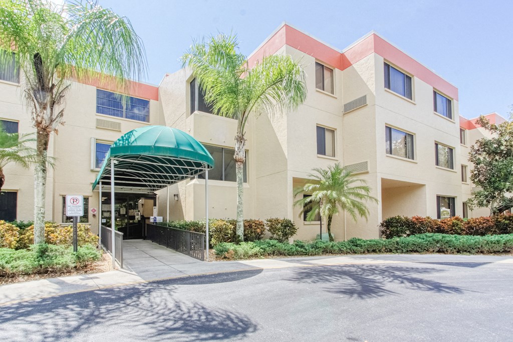 Villa San Carlos Senior Apartments with palm trees and covered entrance