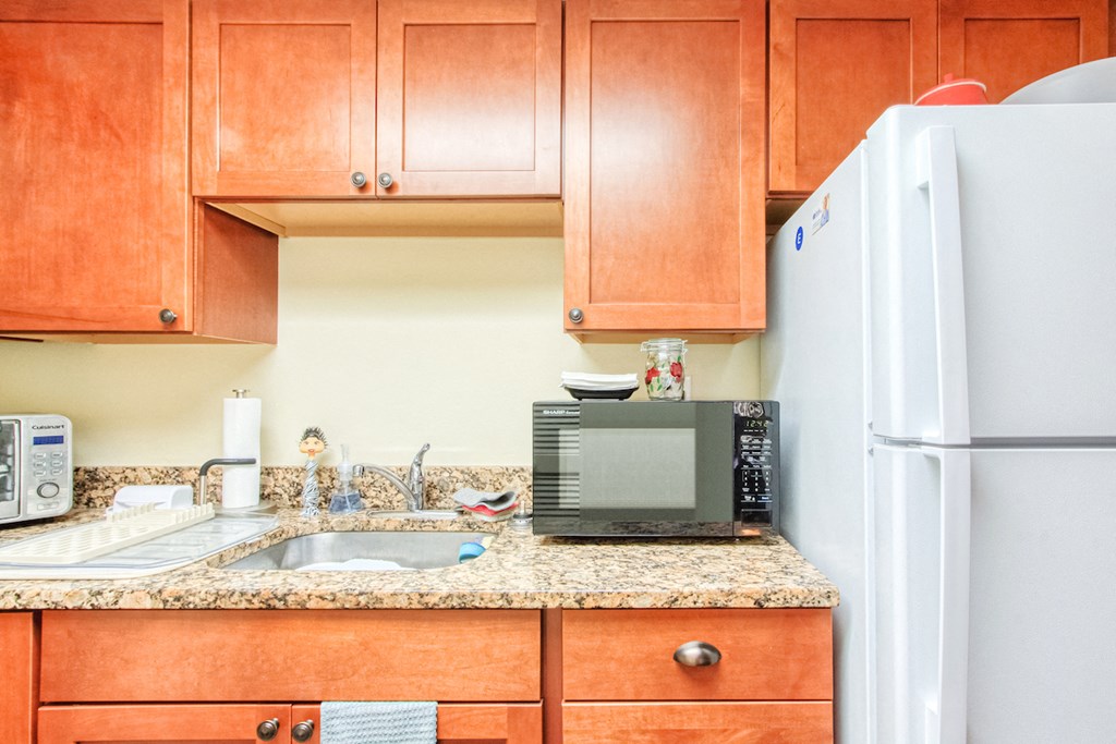wood cabinetry, granite countertops, and stainless steel sink