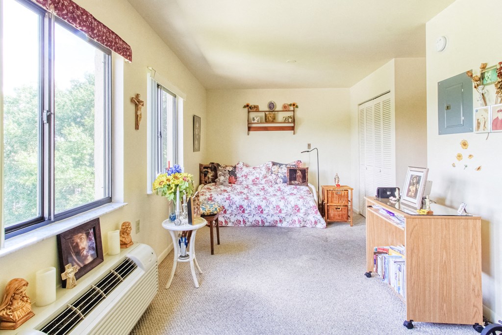 bedroom or sitting room with large windows, closet, and model decor