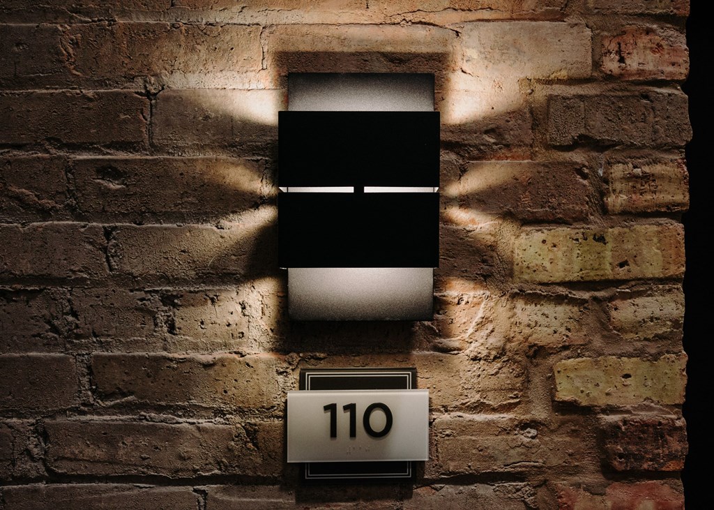 a brick wall with a clock and a light on it