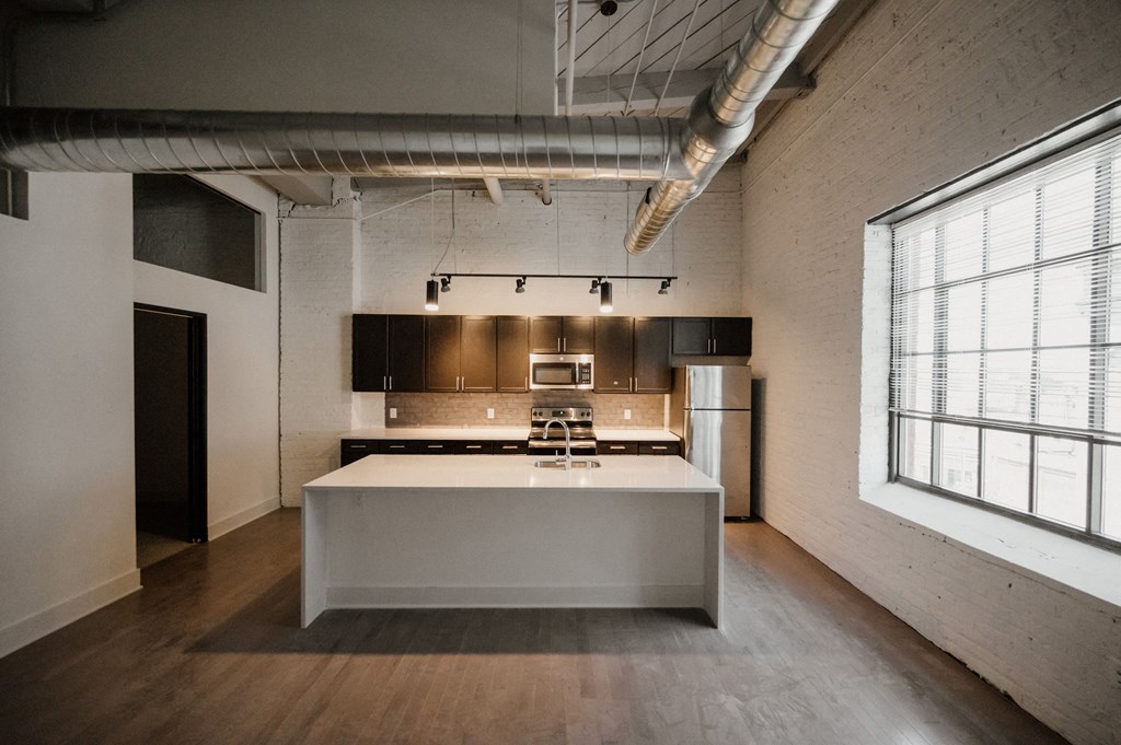 a kitchen with a white island and a large window