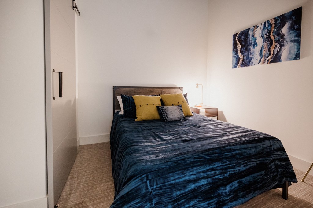 a bedroom with a bed and a painting on the wall