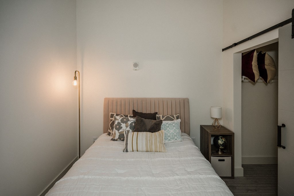 a bedroom with a white bed with pillows and a closet