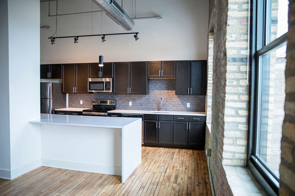 a kitchen with a large window and a white counter top