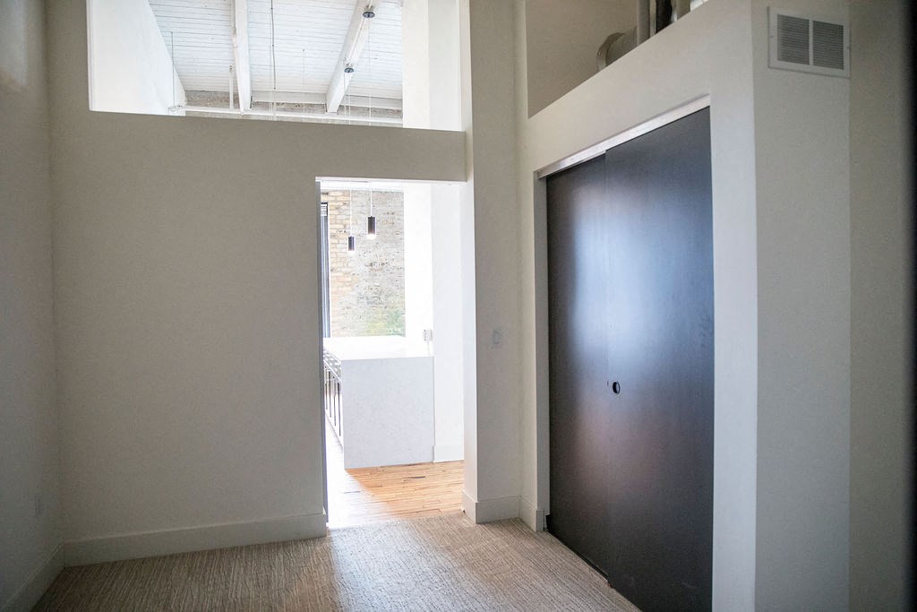 an empty room with a black door and a window