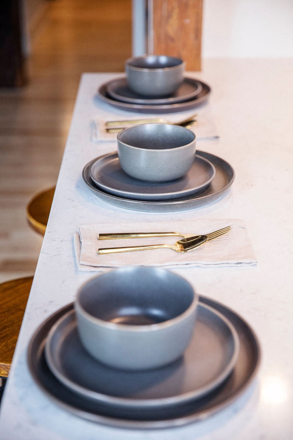 a row of plates and bowls on a counter with plates and utensils