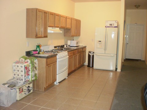 A kitchen with a white fridge and white stove.