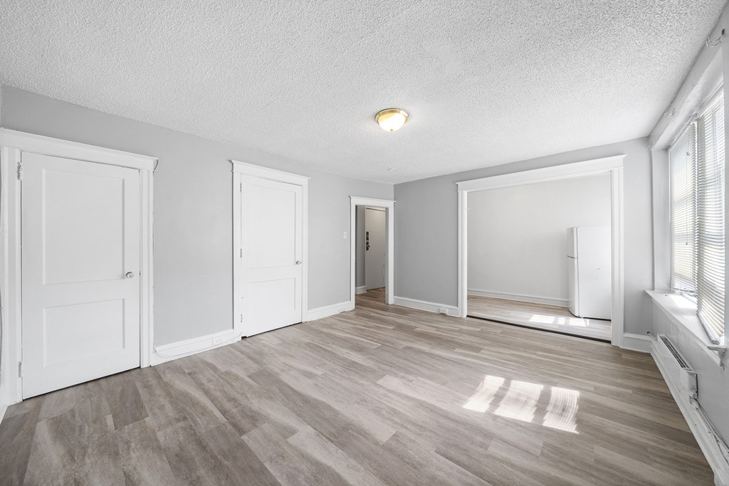 an empty living room with white walls and wood flooring