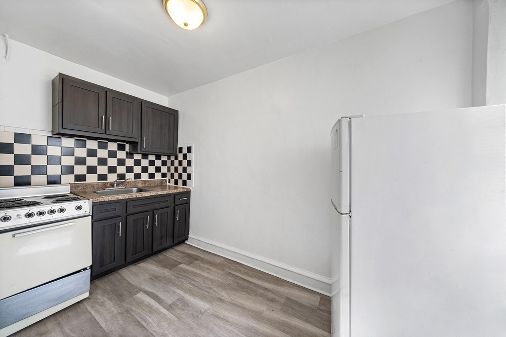 the kitchen of our studio apartment atrium with white appliances and black cabinets