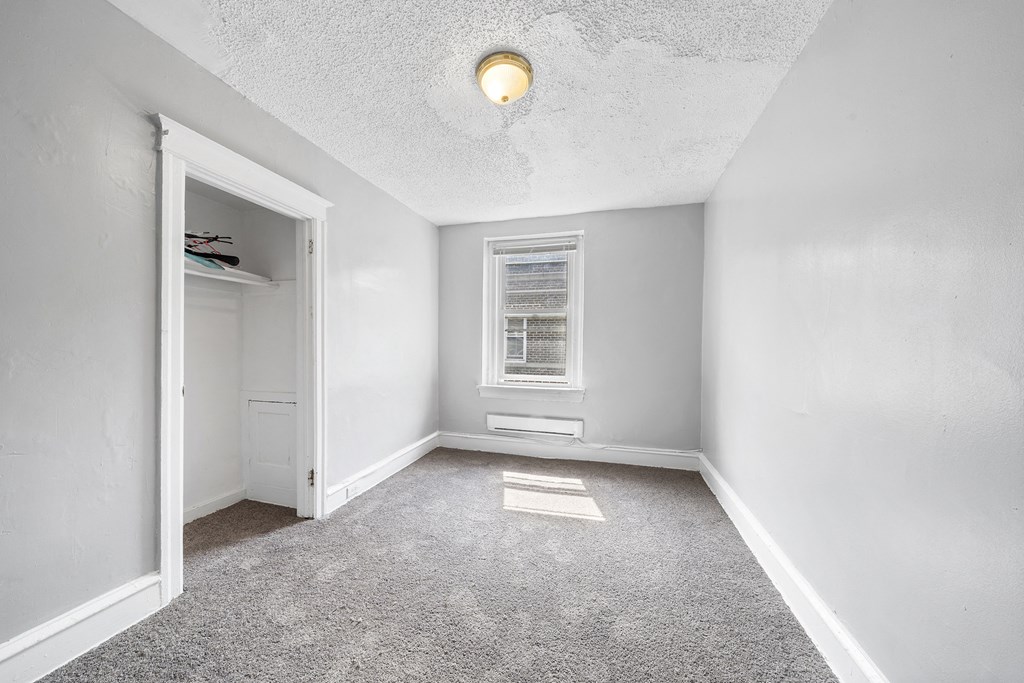 an empty room with a closet and a window